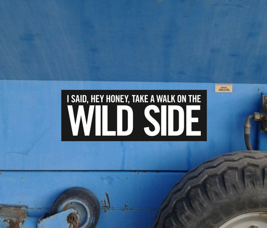 Sticker on a blue vehicle with text 'I said, hey honey, take a walk on the wild side'.