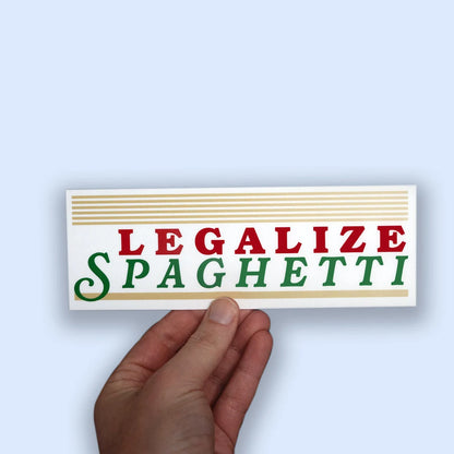 Hand holding a sticker with 'LEGALIZE SPAGHETTI' sticker on a light blue background